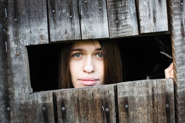 Kobieta Długimi Włosami Piękne Usta Patrzy Okna Drewniane Szopy — Zdjęcie stockowe