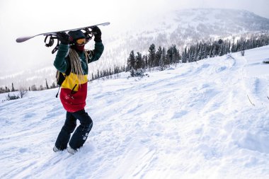 Kadın Snowboard freerider ile karlı bir yamaçta yürüyüş Dağları'nda snowboard.