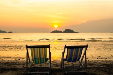 Muhteşem alacakaranlık sırasında deniz plajında şezlonglar.