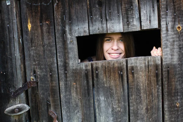 Mujer Joven Mira Sonríe Por Pequeña Ventana Cobertizo Madera —  Fotos de Stock