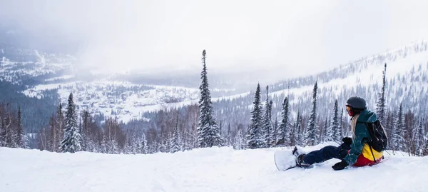Панорамная Картина Сноубордиста Сидящего Горах Снежном Склоне — стоковое фото