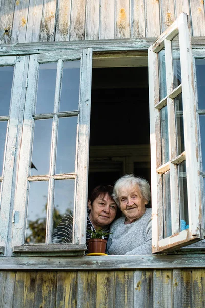 Anciana Hija Adulta Mirando Por Ventana Casa Del Pueblo —  Fotos de Stock