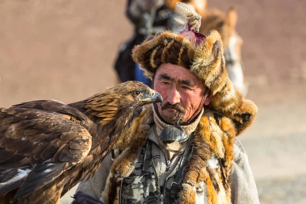 Sagsay モンゴル Sep 2017 Berkutchi イーグル ハンター伝統的な衣類 彼の腕で砂漠山の西モンゴルの黄金のワシを保持しているウサギを狩りながら — ストック写真