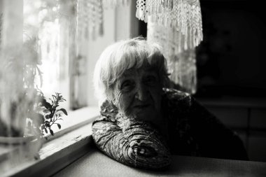 Yaşlı bir kadın ile bir gölge yüzüne portresi. Karanlık tek renkli fotoğraf. 