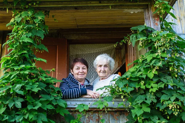 Mujer Anciana Hija Adulta Mirando Hacia Casa Del Pueblo —  Fotos de Stock