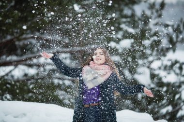 Komik kız kışın inanılmaz parkta kar ile oynuyor.