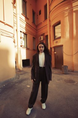 Çekici kız bir Avrupa kentinde avluda poz.