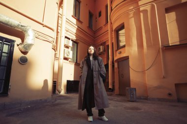 Çekici kız bir Avrupa kentinde avluda poz.