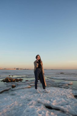 İlkbahar buz ile nehrin yakınında büyüleyici genç kadın.