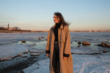 İlkbahar buz ile nehrin yakınında büyüleyici genç kadın.