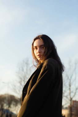 Kamera için poz büyüleyici kız, açık havada.