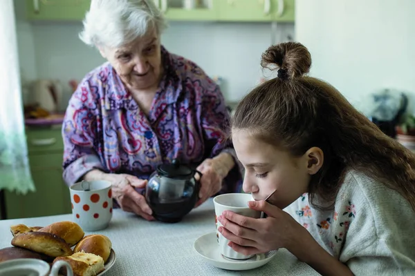一位老妇人给她的孙女喂早餐 — 图库照片