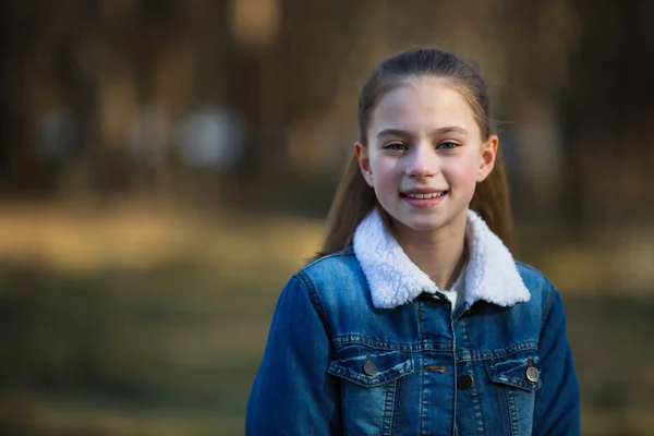 12岁女孩穿着牛仔夹克 在夏日松树公园摆姿势 — 图库照片