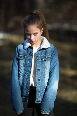 Kot ceketli küçük sevimli bir kız gücenmiş görünüyor..