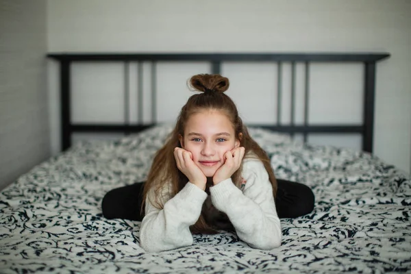 十二岁的女孩坐在她房间里的床上玩得很开心 — 图库照片