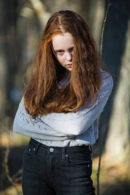 Parlak kırmızı uzun saçlı çekici neşeli genç kız Portresi, bahar Park'ta photoshooting.