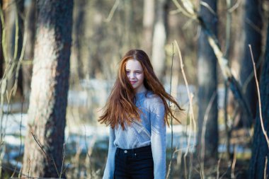 Uzun parlak kırmızı saçlı genç kızın portresi, açık havada.