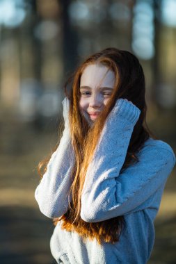 Kızıl saçlı küçük kız Park'ta bir portre için poz.