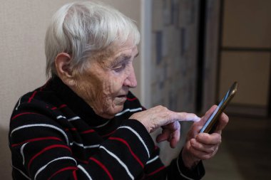 Yaşlı kadın emekli bir akıllı telefon üzerinde yazarak.