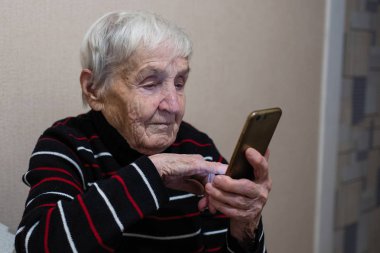 Yaşlı kadın emekli bir akıllı telefon üzerinde yazarak.