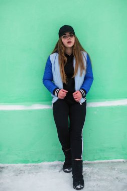 Yeşil duvara yakın genç kız portresi.