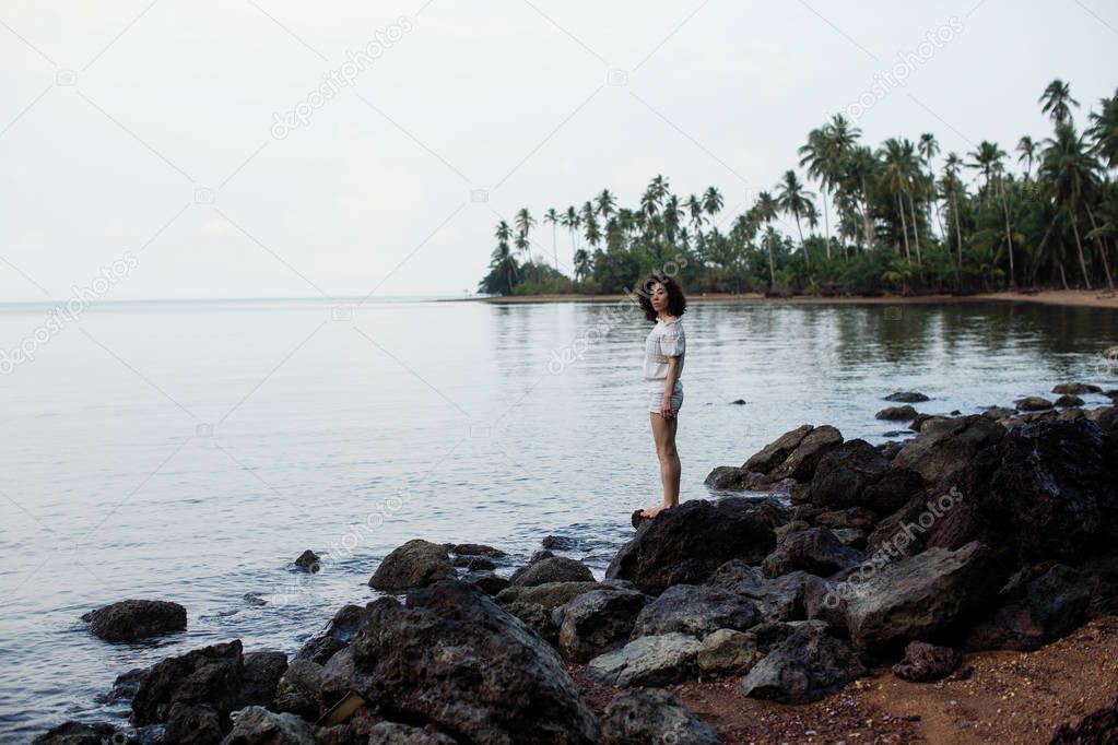 Young asian woman on the coast of a tropical sea beach.