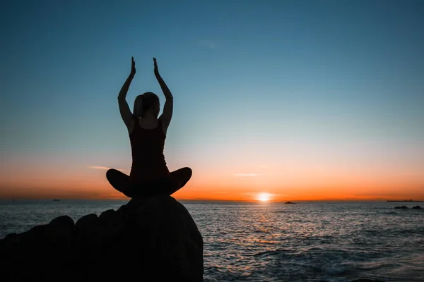 海と夕日の背景にシルエット瞑想のヨガの女の子 — ストック写真