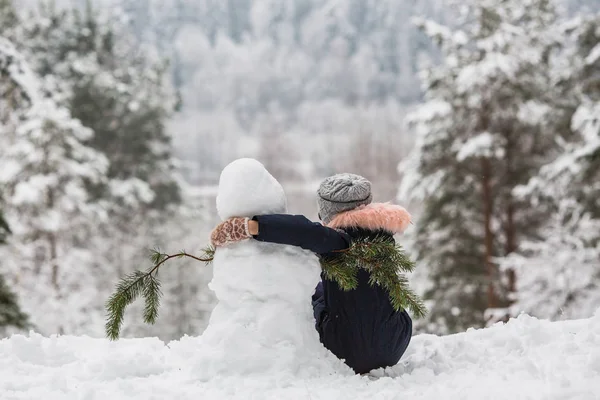 Вид Спереду Маленька Дівчинка Сидить Обіймаючись Один Одним Сніговиком Зимовому — стокове фото