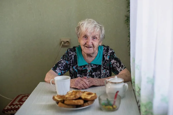 Παλιά Ρωσική Γυναίκα Κάθεται Στο Τραπέζι Της Κουζίνας — Φωτογραφία Αρχείου