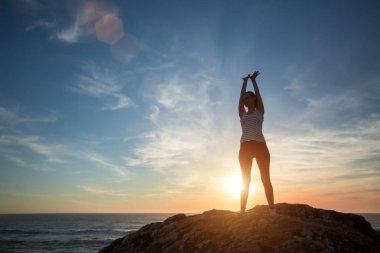 Deniz sabah egzersizleri arka planda Siluet fitness yoga kız şafak karşılamaktadır. Sağlıklı yaşam tarzı. 
