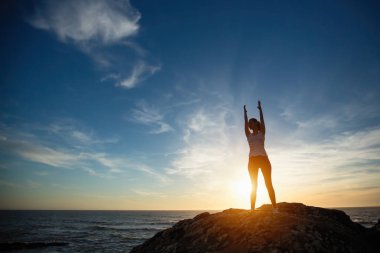 Fitness yoga kız siluet, deniz plajı gün batımında sabah egzersizleri. 