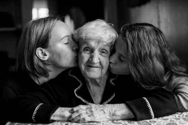 两个女孩亲吻他们的祖母 黑白肖像 — 图库照片