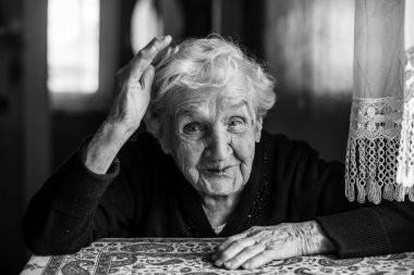 Evinde duygusal yaşlı kadının siyah-beyaz portresi.
