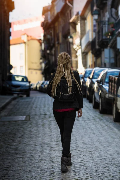年轻女子走过狭窄的人行道街道 后视图 — 图库照片