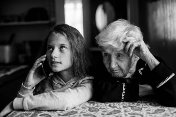小女孩孙女在用手机说话 奶奶听她说话 黑白照片 — 图库照片