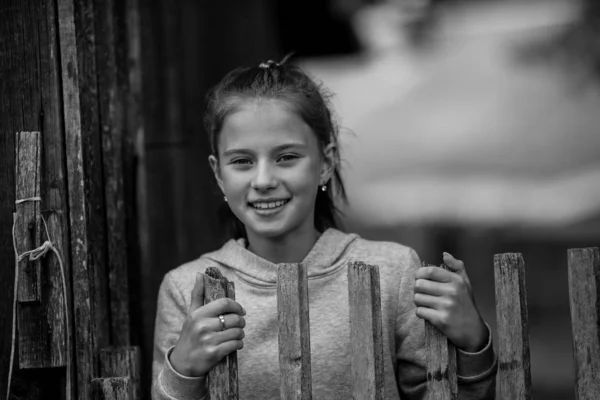 木製の村のフェンスの近くに十代の少女の肖像画 白黒の肖像画 — ストック写真