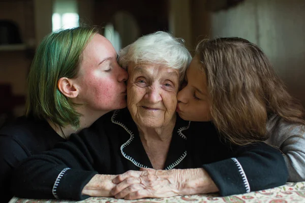 Две Девушки Целуют Свою Бабушку — стоковое фото