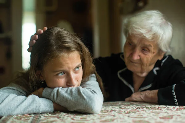 Yaşlı Bayan Büyükanne Bir Ağlayan Küçük Kız Torunu Rahatlatıyor — Stok fotoğraf