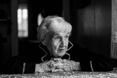 Yalnız ve üzgün yaşlı bir kadının portresi. Siyah beyaz fotoğraf.