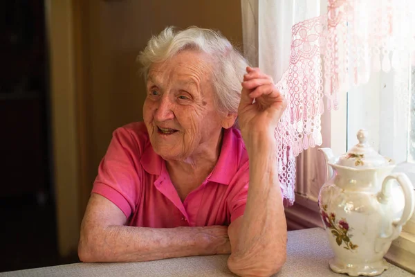 Portret Van Cheerfulbejaarde Vrouw Zittend Aan Tafel — Stockfoto