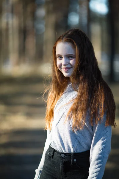 松の公園で燃えるような赤い髪を持つかわいい十代の少女の肖像画 — ストック写真
