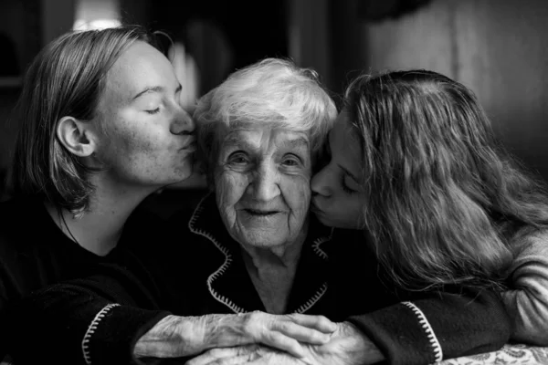 Zwei Enkelinnen Küssen Seiner Alten Großmutter Die Wangen Schwarz Weiß — Stockfoto
