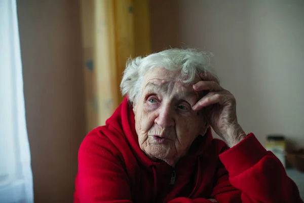 Lonely Old Woman Her House Sitting Table Red Jacket Plight — Stock Photo, Image