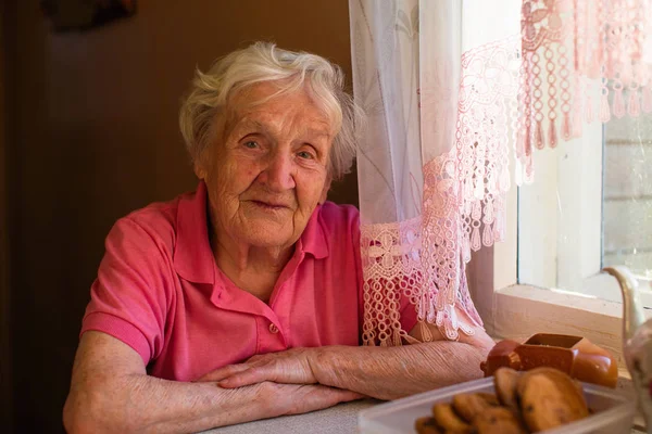 Portrait of elderly woman in her home at kitchen.