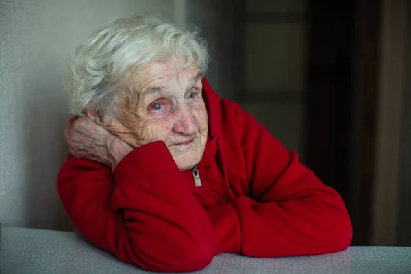 Evinde Çok Yaşlı Bir Kadın Emekli Kırmızı Ceketli Bir Masada — Stok fotoğraf