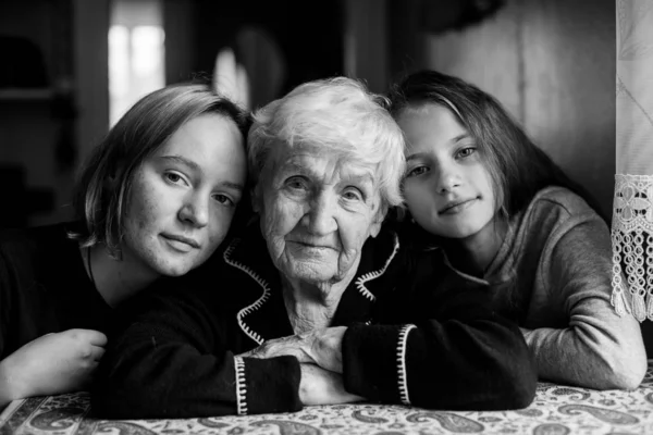 Granny posing with her two girls-granddaughters. Black and white photo.