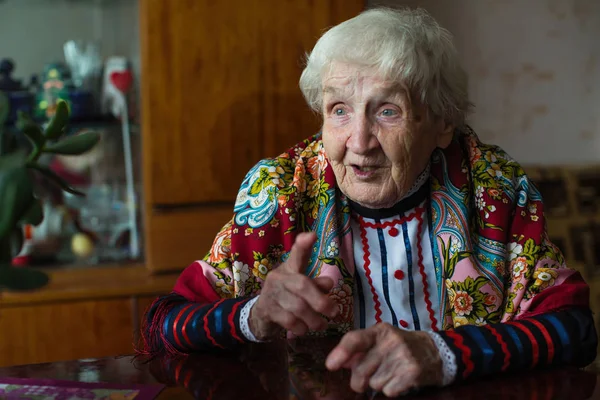 Een Oude Dame Heldere Kleren Gebaren Zittend Aan Tafel — Stockfoto