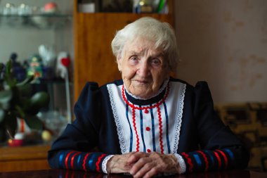 Evinde Kazak kıyafetleri giymiş yaşlı bir kadın..