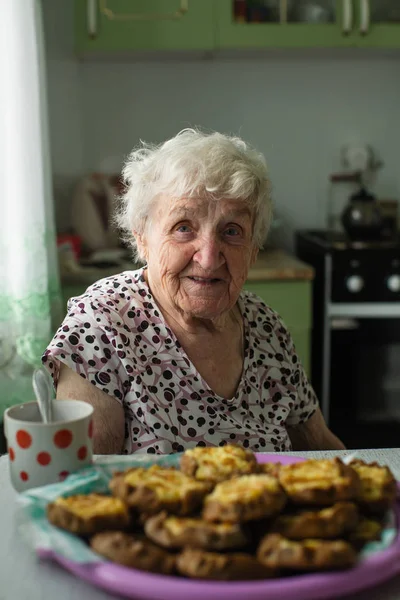 Büyükannem Mutfakta Hamur Işleri Ile Oturuyor — Stok fotoğraf
