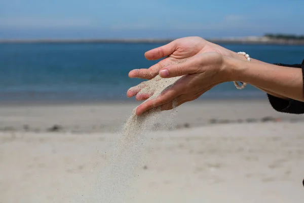 Areia Derrama Através Dos Dedos Contra Oceano — Fotografia de Stock